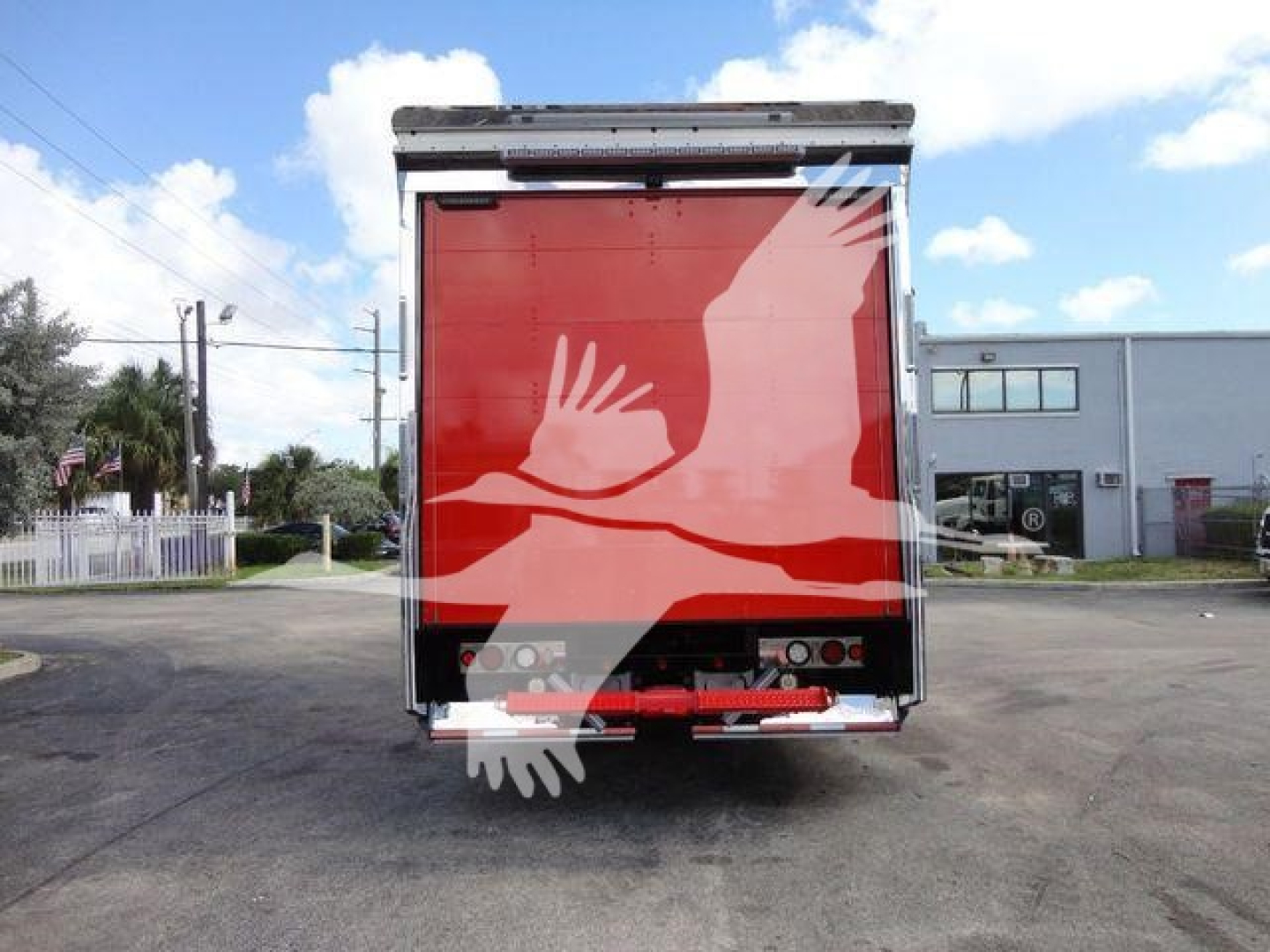 MD6 rollback truck rear showing red cargo door with white graphic hands image partial. Tail lights and bumper visible.