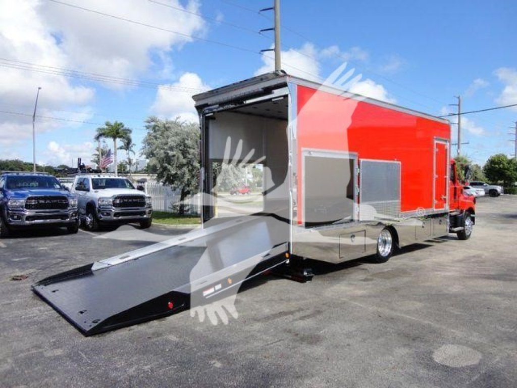 MD6 rollback truck showing open rear with lowered loading ramp and red cargo body, side compartments, and chrome lower paneling.