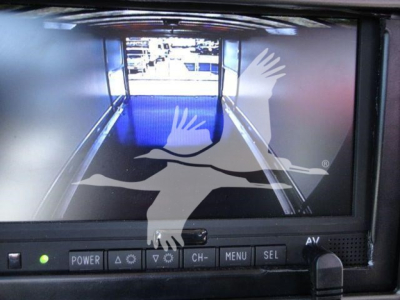 MD6 rollback truck display showing rear view camera screen with control buttons below and a delivery graphic overlay.