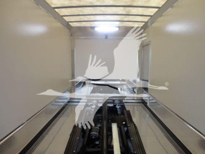 Trucked image of a Mack MD6 rollback truck interior with metal floor and wheel chocks visible, no readable labels inside the trailer.