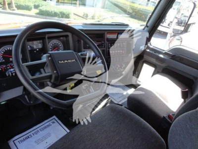 MD6 cab interior showing steering wheel with MACK logo, dashboard gauges, and driver seat in a new Mack MD6 rollback truck.