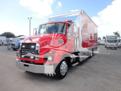 Mack MD6 rollback truck in red with box body visible in showroom lot.