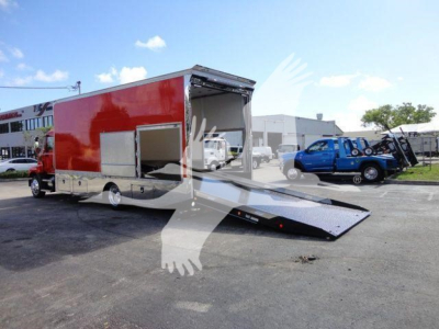 MD6 rollback tow truck in red with rear ramp extended showing cargo area and entry door.