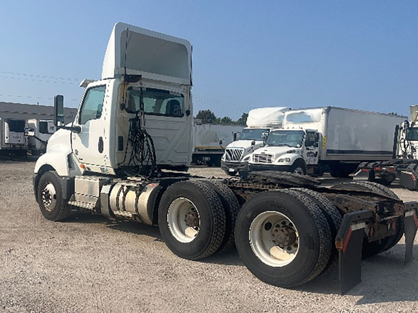 Truck chassis with sleeper cab, International LT625, side view showing dual rear axles and fifth-wheel area.