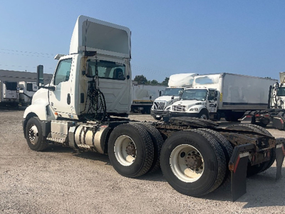 Truck chassis with sleeper cab, International LT625, side view showing dual rear axles and fifth-wheel area.