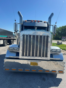 Peterbilt 379 Extreme front view showing tall vertical exhaust stacks and chrome grille with bumper and yellow license plate.