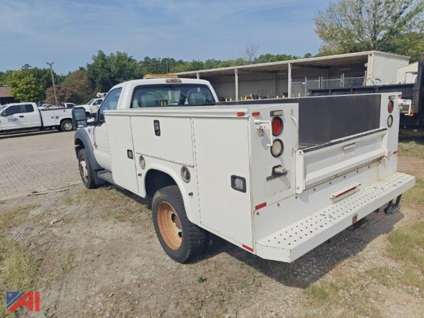 Ford F550 Super Duty utility/cab chassis with service body showing rear cargo bed and dual rear wheels.