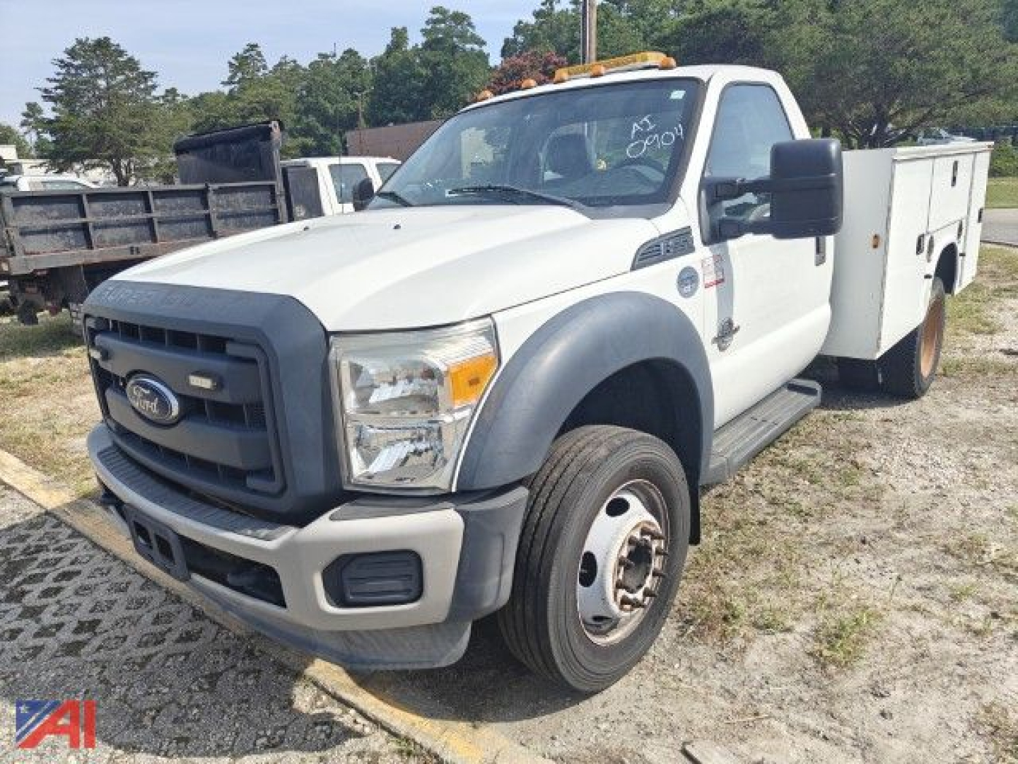 Ford F-550 Super Duty utility truck, white cab with black grille, large side mirrors, utility box on rear and front bumper-step, 2wd single rear wheel, daylight outdoor lot.
