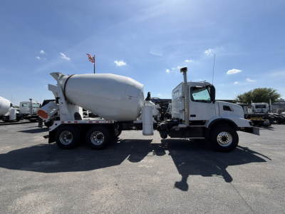 Volvo VHD64B300 mixer truck side view showing cement mixer drum and cab with chrome exhaust stack.