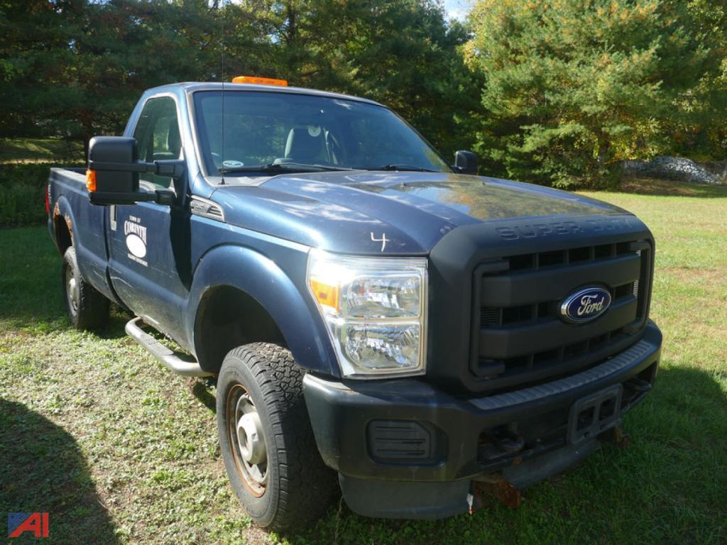 Ford F-250 Super Duty pickup truck with single rear wheel visible, blue body, black grille, front view showing Ford emblem and bumper, orange clearance light on cab roof.