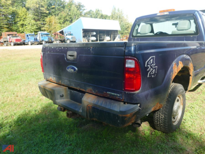 Ford F-250 Super Duty rear view showing tailgate, bumper, and 4x4 badge with rust on wheel well and single rear wheel.