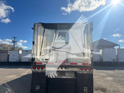 Truck trailer rear showing dump bed with taillights and hydraulic components, label reading TAPCO East and D4 on the back gate.