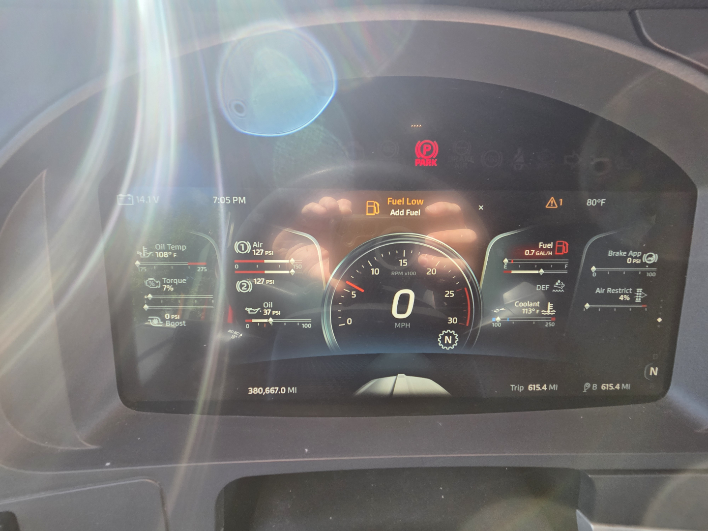 Dashboard cluster of a Kenworth T680 showing digital gauge readouts, fuel low alert, and various warning icons.