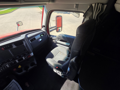 Kenworth T680 cab interior showing driver seat and dashboard with steering wheel and side window
