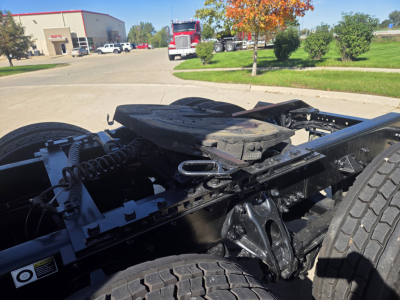 Kenworth T680 chassis view showing fifth wheel mount and drive tires with visible frame and drivetrain components.