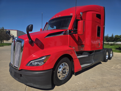 Kenworth T680 conventional sleeper truck in red, front-left view, showing cab, chrome grille, dual rear wheels, side mirrors, and aerodynamic features.