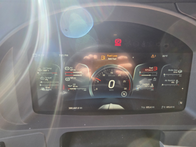 Dashboard cluster of a Kenworth T680 showing digital gauge readouts, fuel low alert, and various warning icons.