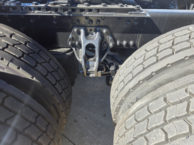 Kenworth T680 rear drivetrain area showing dual rear wheels and hitch/air suspension mounting plate with surrounding chassis members.