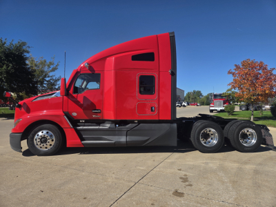 Kenworth T680 semi-truck in red from side view showing sleeper cab and dual rear axles.