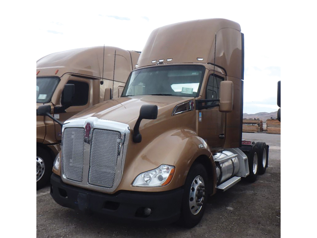 Kenworth T-680 cab with sleeper in tan color, front grille, dual rear axles, daytime cab truck in a staging lot.