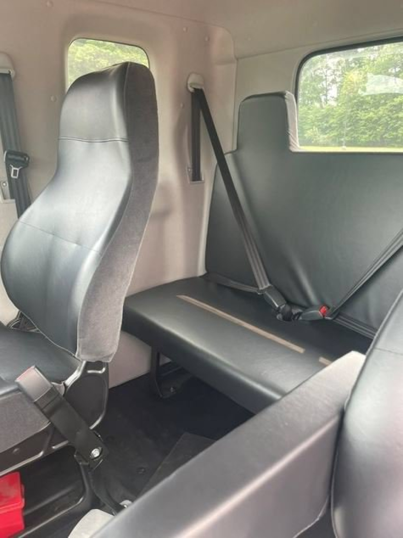 Cab chassis interior showing seats and seat belts with side windows.