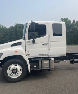 Hino L6 cab chassis truck side view showing two-door cabin with small window, wheel, and side fuel/air tanks. Visible text includes 'HINO' and 'NSeries' on cab area and components.