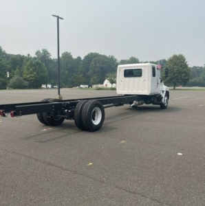 Truck chassis with long rear frame and cab, rear axle and dual tires, white cab, 5PVNJ7EY7V5T50276 visible VIN.