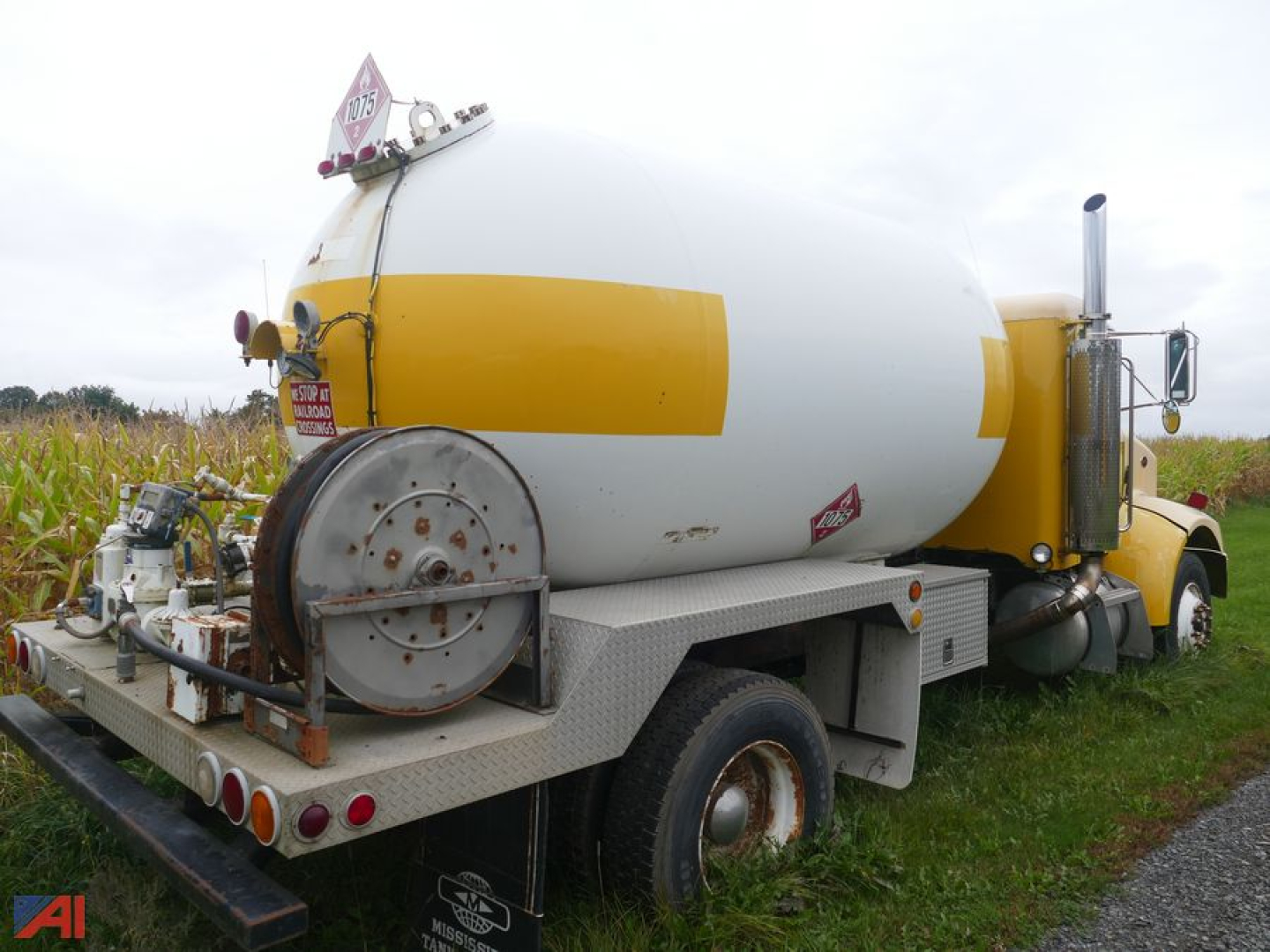 Peterbilt 330 LPG truck rear/side view with large white and yellow propane tank, metal platform, hoses, and equipment.