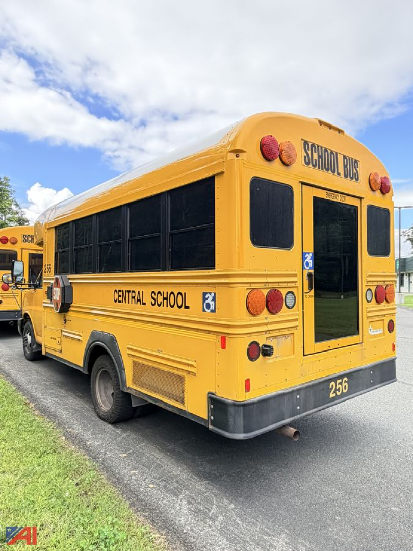 School bus rear view showing wheelchair accessibility area and 'CENTRAL SCHOOL' lettering, yellow body with 'SCHOOL BUS' at top rear, bus number 256, on a paved lot.