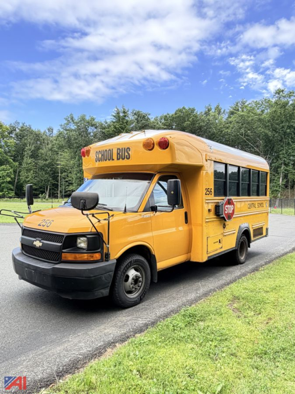 Yellow 2017 Chevrolet Express school bus with wheelchair lift parked on road, side view showing stop sign and school bus lettering.
