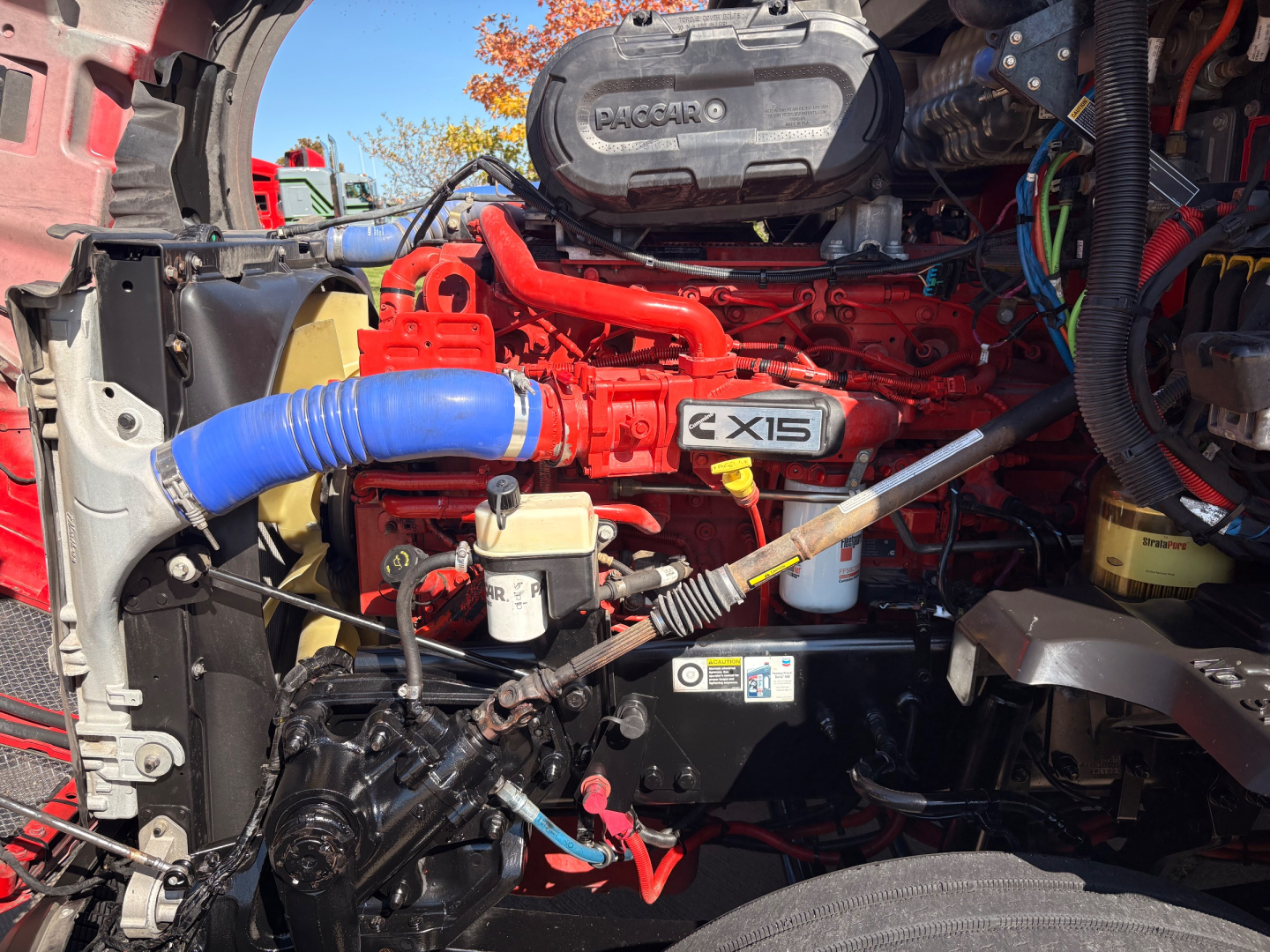 Kenworth T680 engine bay showing X15 engine label and surrounding hoses and components.