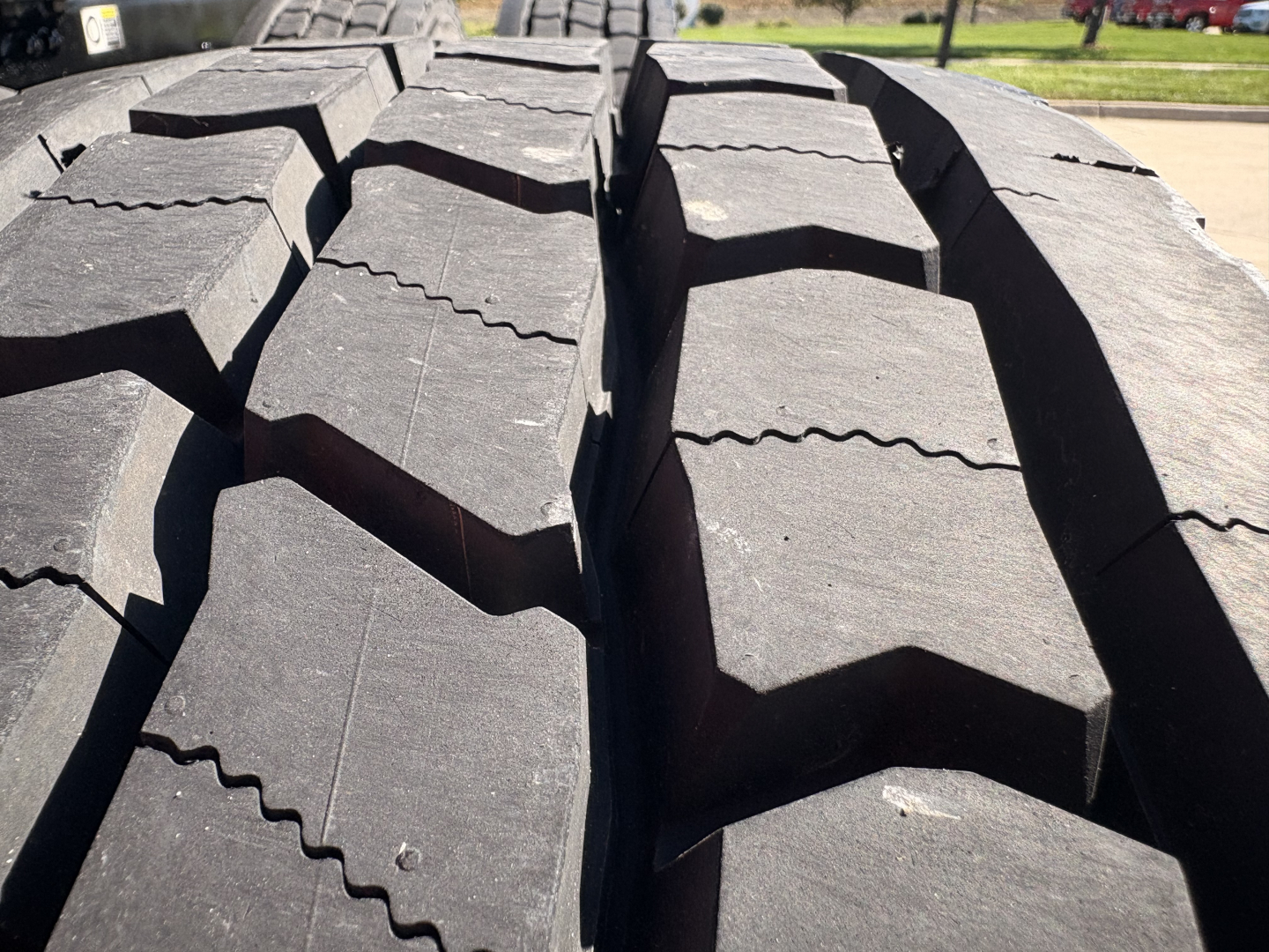 Kenworth T680 truck tires close-up view showing large tread blocks and groove patterns.