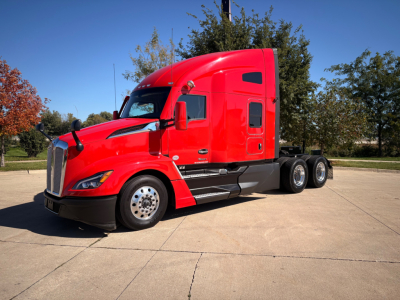 Kenworth T680 sleeper cab in red, side view showing front and rear wheels and cab details.
