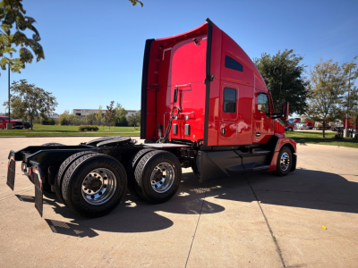 Kenworth T680 sleeper cab semi-truck side/rear view showing red cab, black chassis, six wheels, and absent trailer.