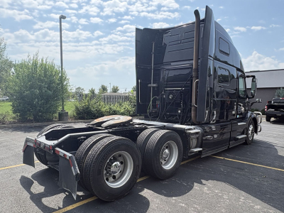 Volvo VNL 780 tractor in-service, rear view showing dual rear axles, fifth-wheel, and black sleeper cab with polished fuel tanks.