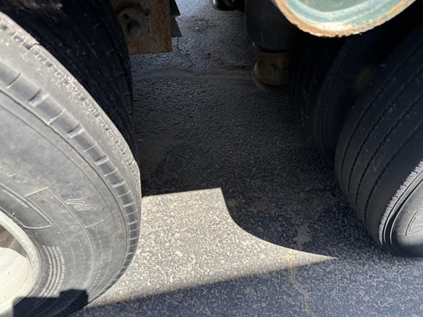 Trail King lowboy trailer wheel area showing dual rear axles and tires with visible tread and metal frame undercarriage.