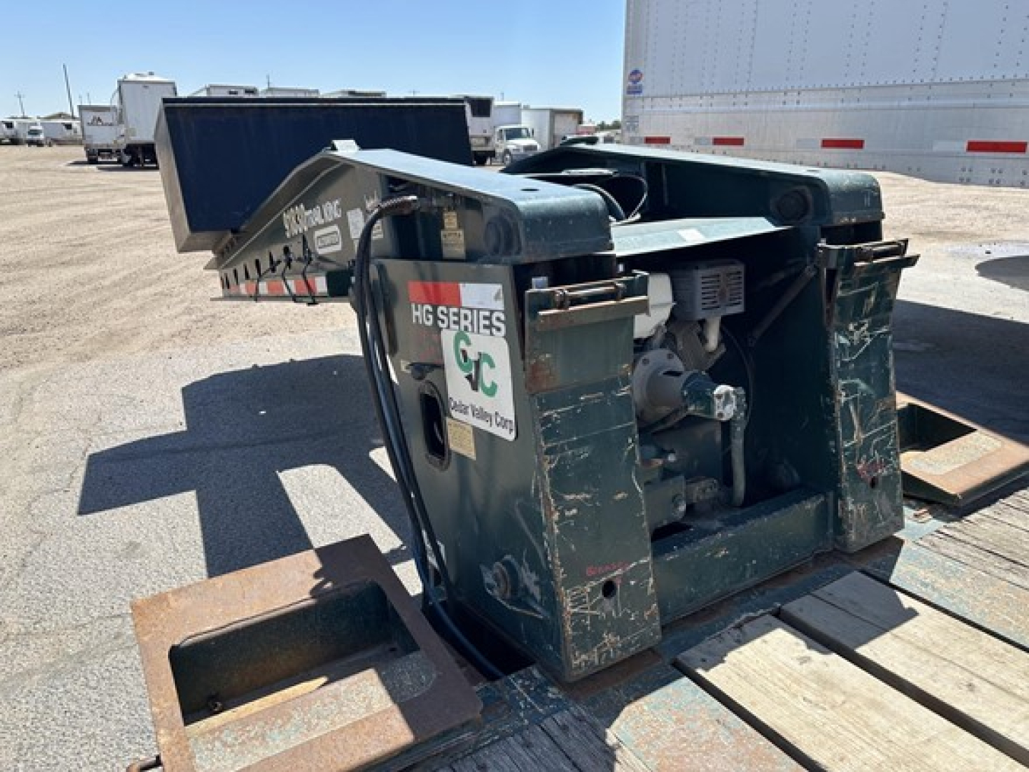 Trail King lowboy trailer gooseneck coupler and hitch assembly with green metal frame and drive motor visible; HG Series sticker and GC logo on side.