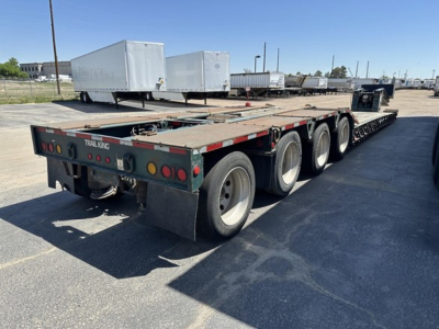 Trailer: 2012 Trail King lowboy multi-axle flatbed trailer with green rear and red/white reflective striping, showing three axles on each side and dual rear lights.