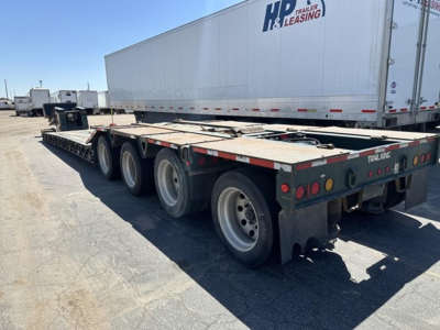 Trailer King lowboy trailer with multiple axles and a large flatbed surface; rear showing taillights and bumper.