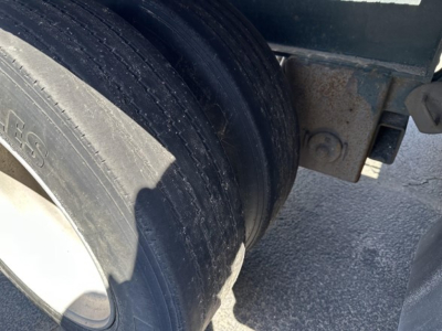 Trail King lowboy trailer wheel area showing dual tires and frame mounting point.
