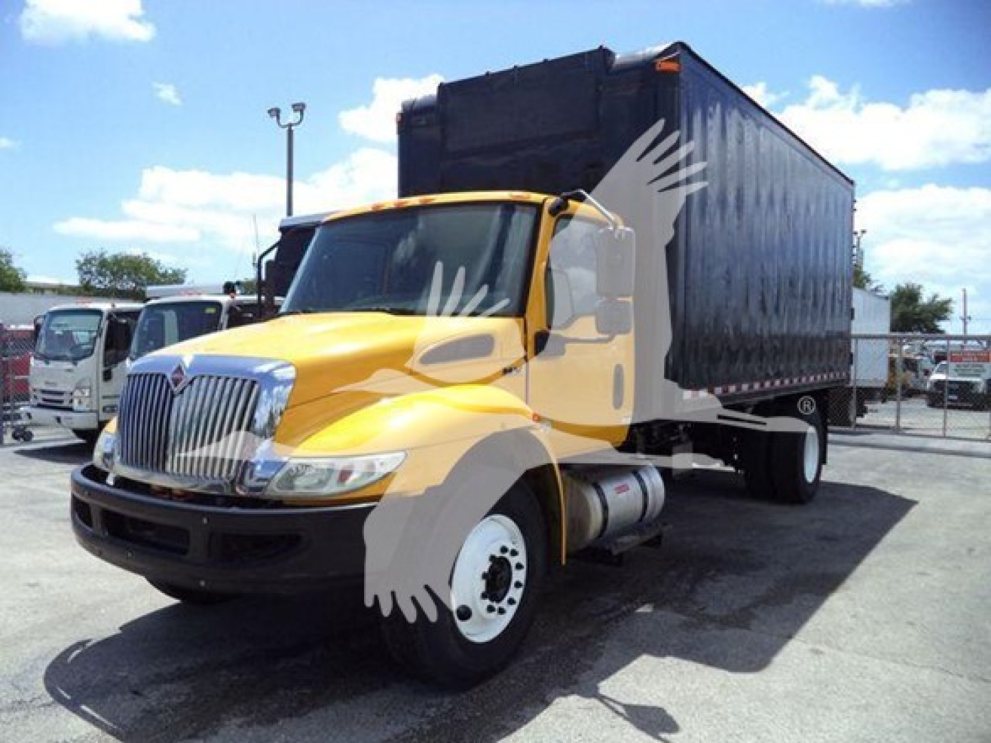 Truck cab with yellow hood and black dump bed, International MV 2020 model, side view showing front grille and wheel.