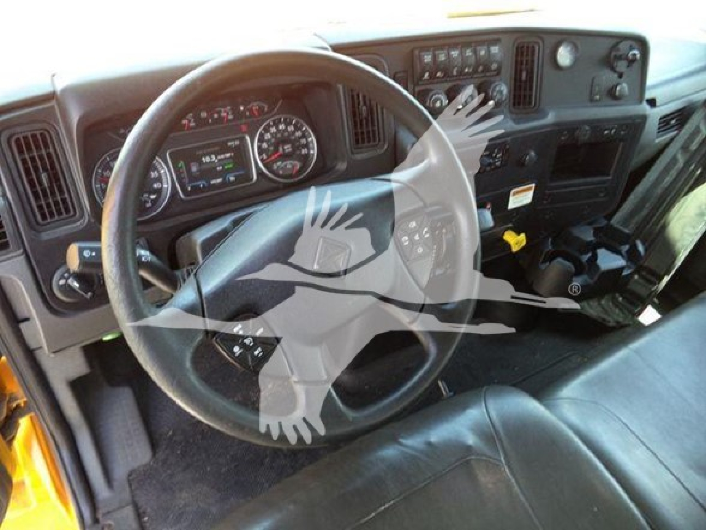 Dashboard and steering wheel of a 2020 International MV truck cab showing instrument cluster, steering wheel, and center stack with gauges and controls.