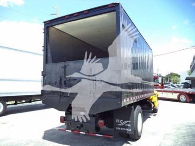 Truck trailer rear view showing open cargo area and taillights with TLC trailer nearby.
