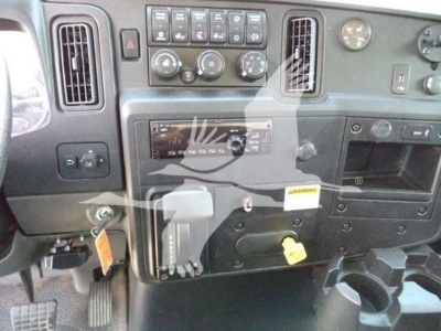 Truck cab dashboard and center console showing HVAC controls, radio, ignition area, and yellow keys with tags.