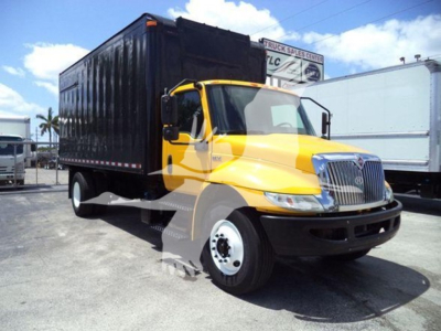 Truck cab with yellow body and black cargo box. Front grille with chrome, white front bumper, black wheel wells. Side shows no text clearly visible.