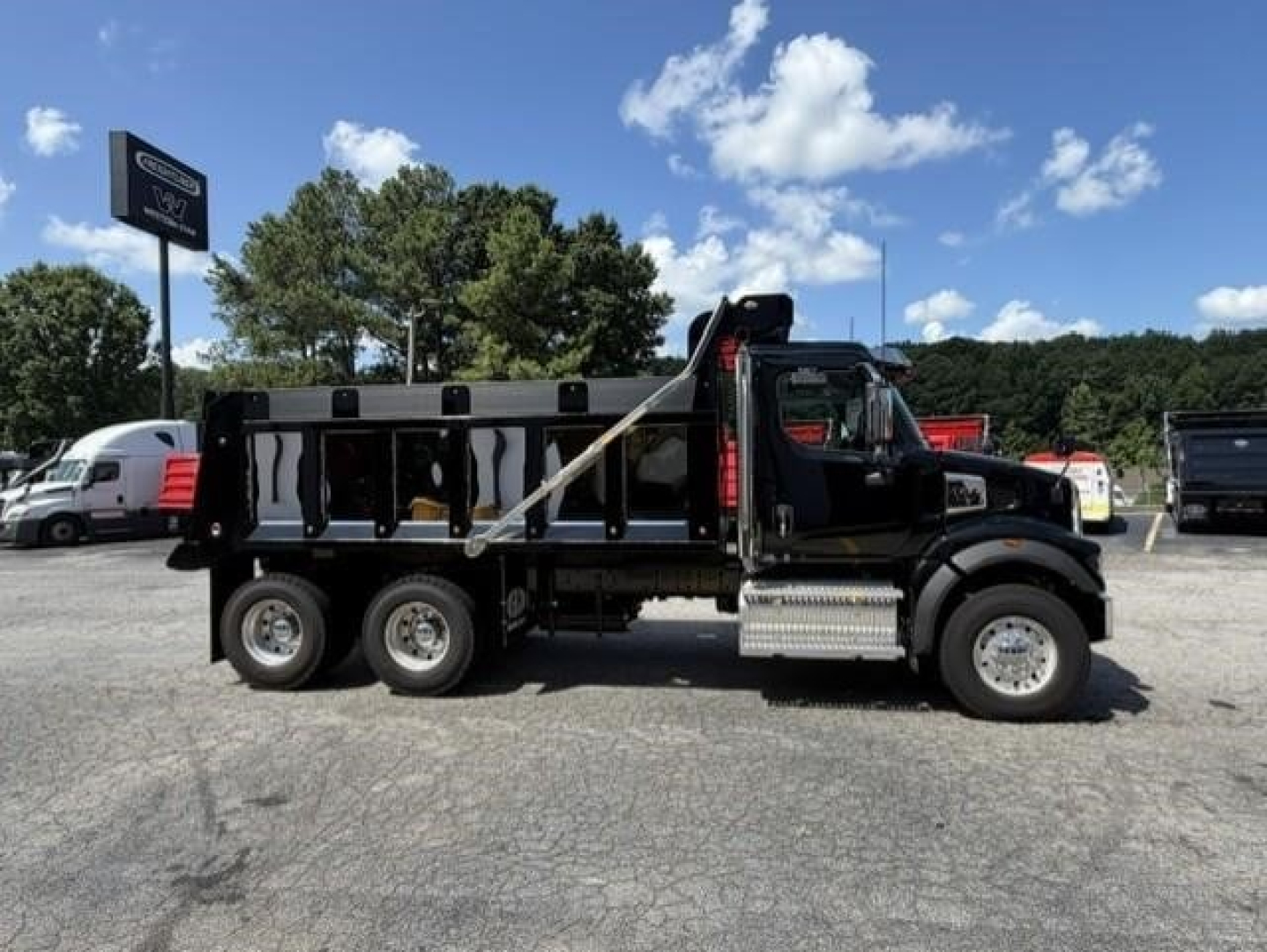 Dump truck side view showing Western Star 47X with black body and dump bed.