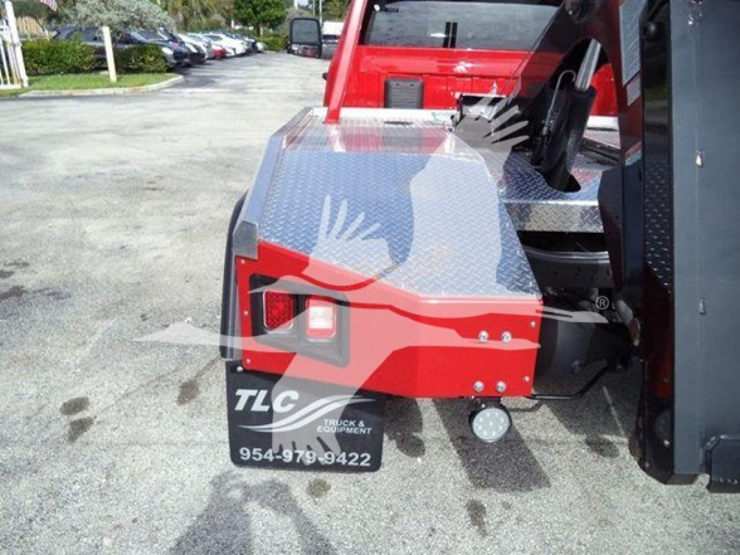 Ram 4500 SLT rear-quarter showing winch equipment and red body panels with diamond plate storage box and TLC logo sticker.