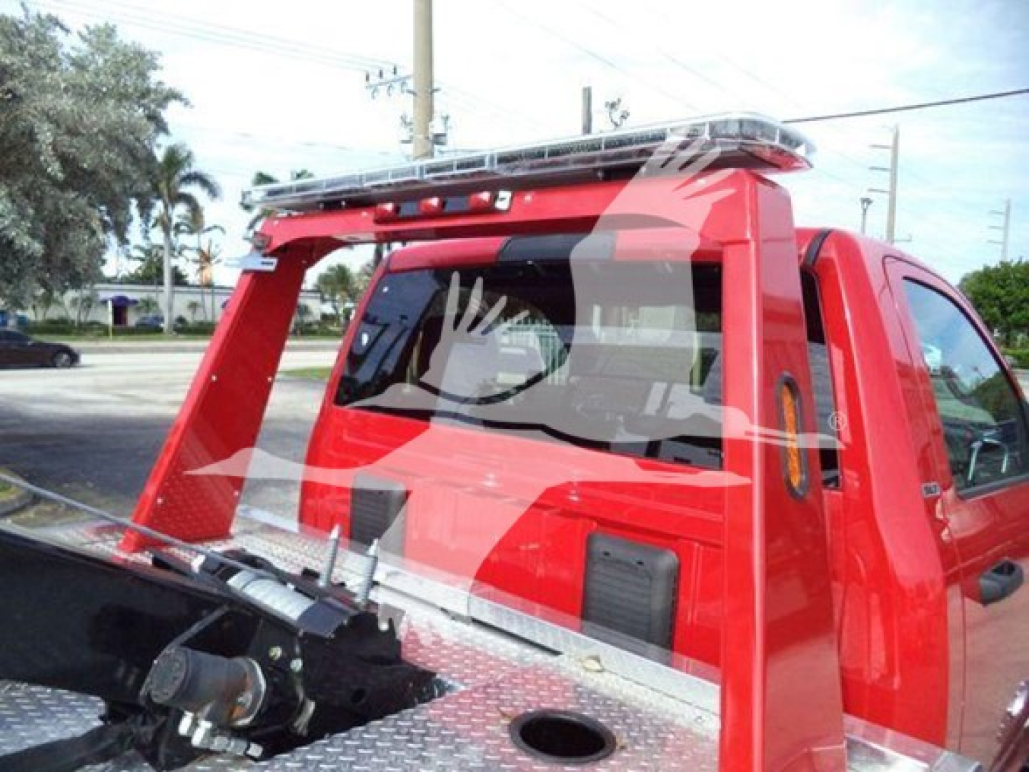 Red Ram 4500 pickup with winch equipment and roll bar, side windows, and metal deck; view shows rear cabin and load bed with winch apparatus.