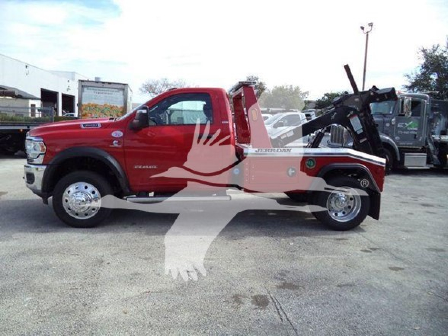 Ram 4500 tow truck in red with hydraulic crane on bed, side view showing cab and long wheelbase, stock J64735