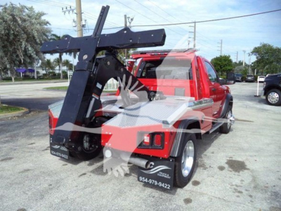 Truck rear-side view showing a heavy-duty winch hitch setup on a red Ram 4500 SRt with a black articulated mount and towing hooks.
